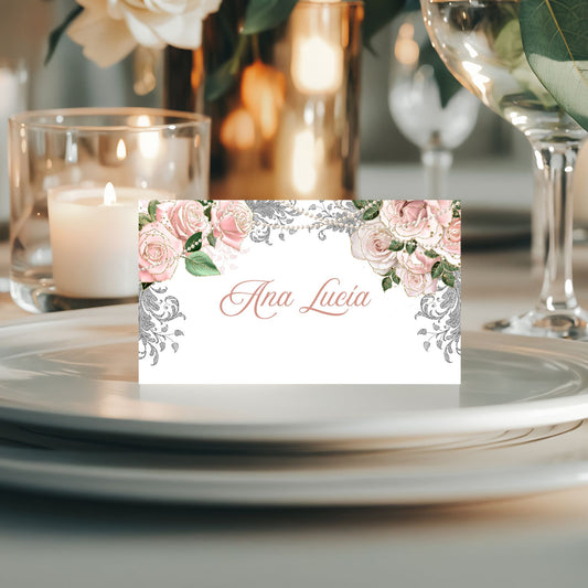 Decorative place card with floral design pearls and 'name' text on a table setting with candles and glasses.