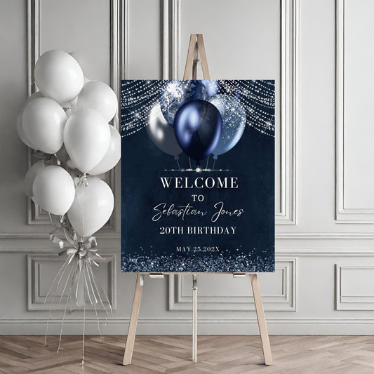 Birthday welcome sign with balloons on an easel against a gray wall.