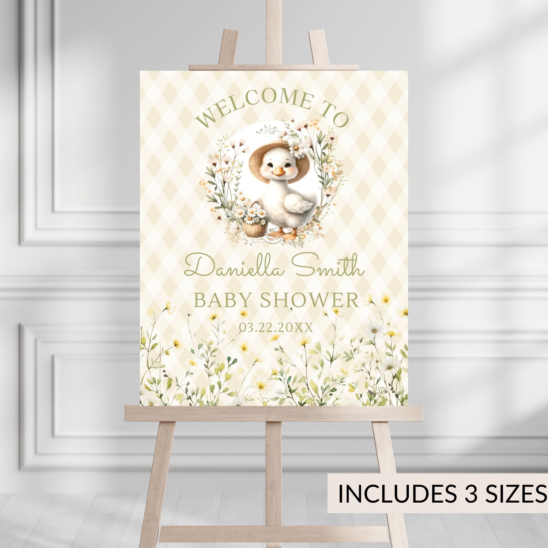 Baby shower welcome sign with a duck design on an easel against a gray wall.