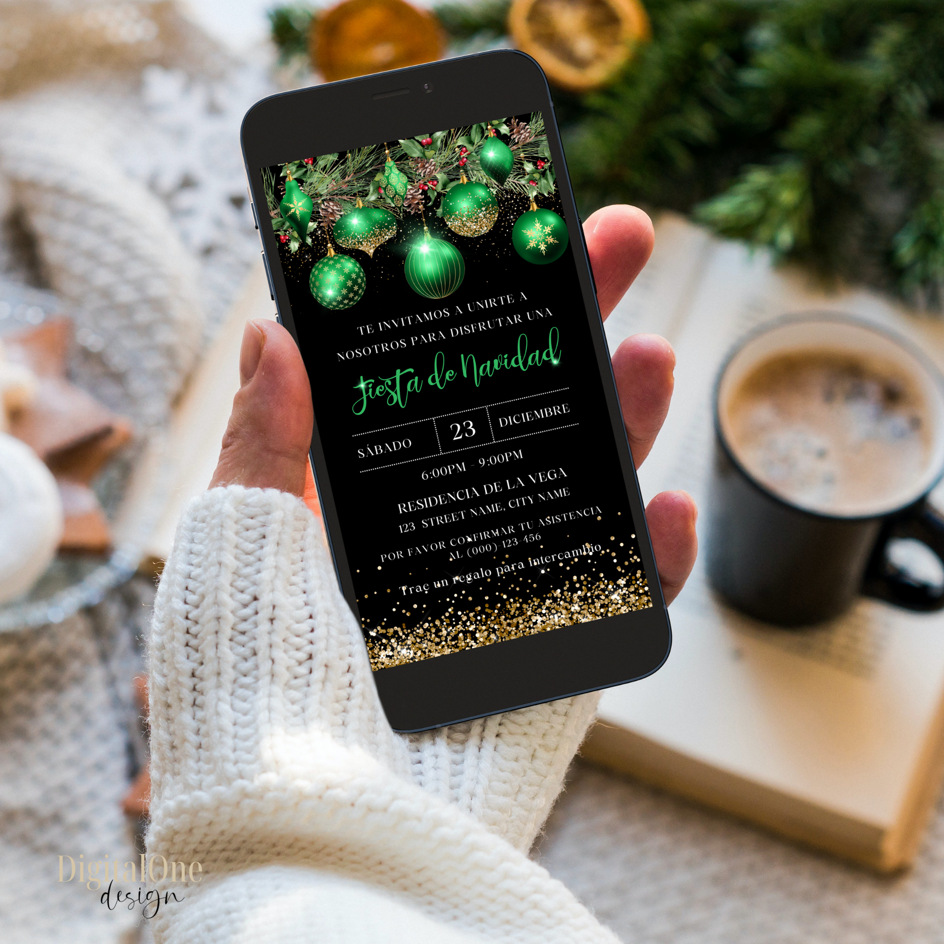 Hand holding a phone with a Spanish Christmas-themed invitation on a cozy background with a mug and decorations.