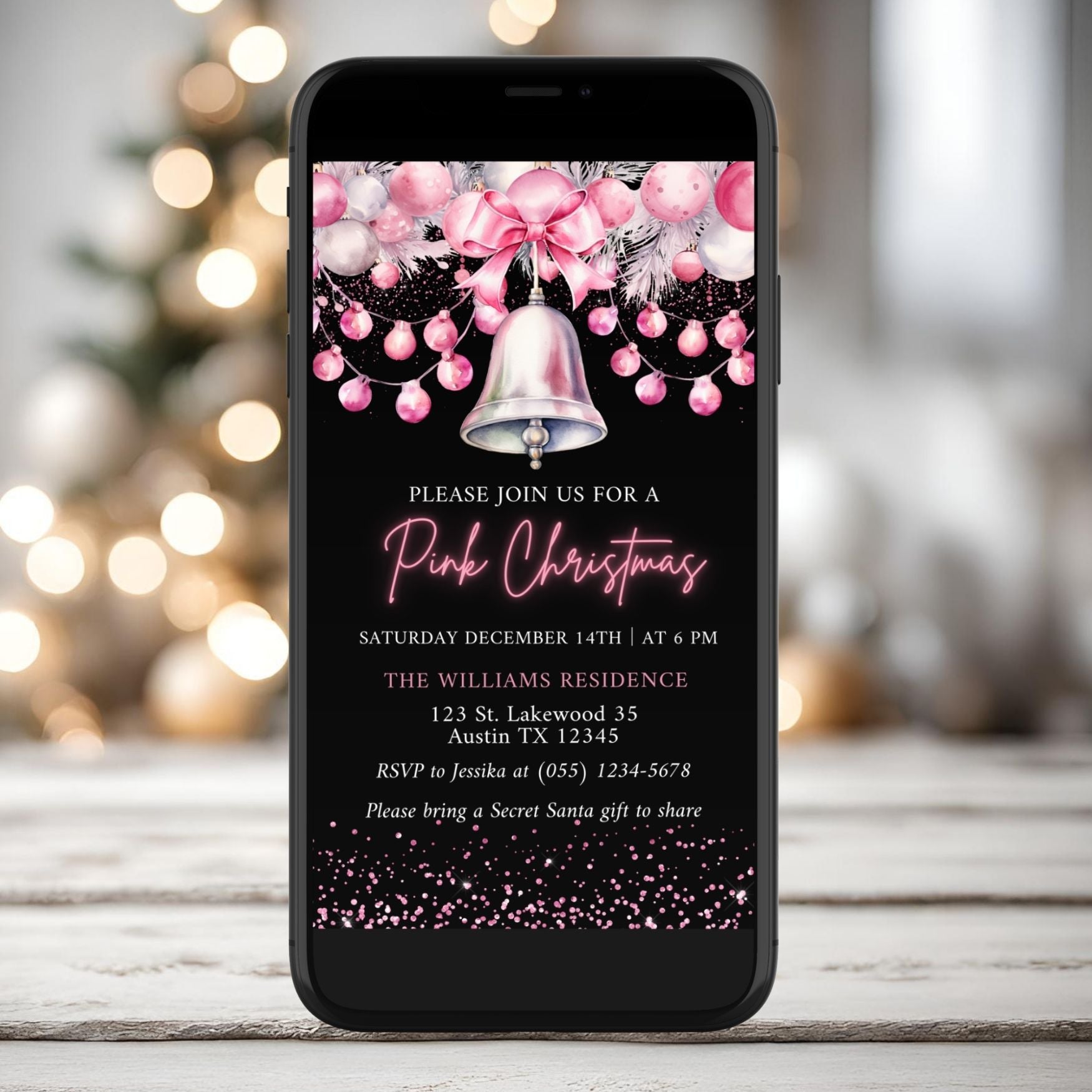Phone with a pink Christmas invitation on a blurred festive background