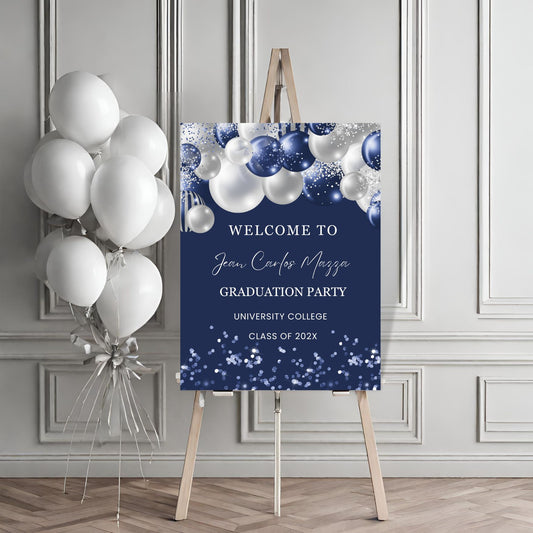 Graduation party welcome sign with balloons against a gray wall.