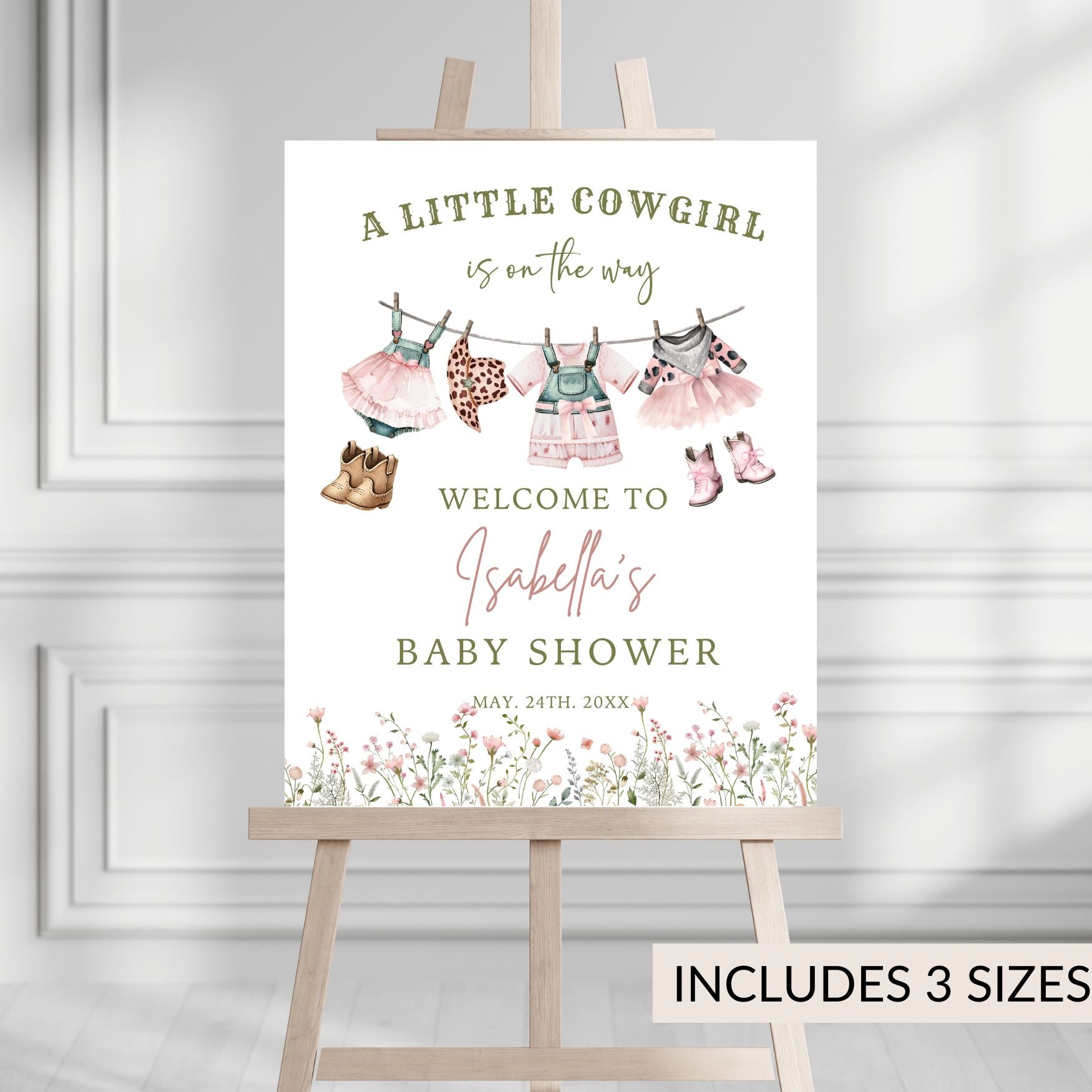 Baby shower invitation with cowgirl theme on a wooden stand against a gray background