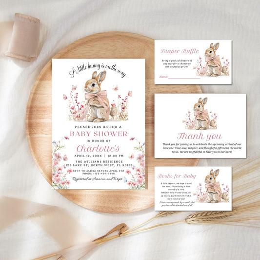 Baby shower invitation set with bunnies on a wooden tray