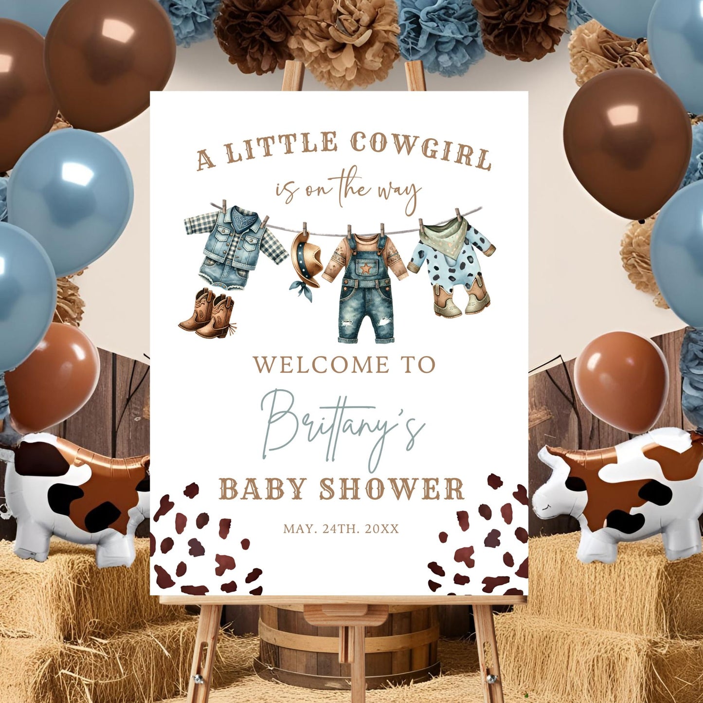 Baby shower sign for a little cowgirl with balloons and hay bales in the background