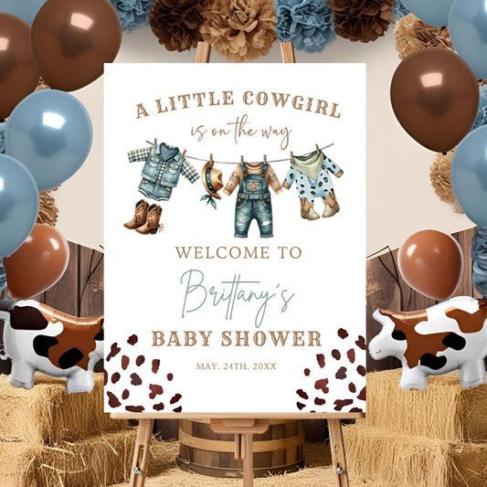Baby shower sign for a little cowgirl with balloons and hay bales in the background