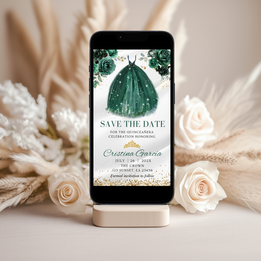 Phone displaying a Emerald green dress invitation with flowers on a stand with decorative flowers in the background