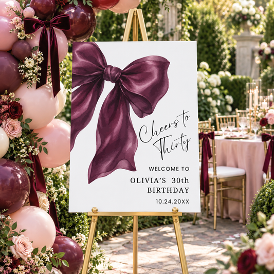 Elegant Burgundy Coquette Bow Birthday Welcome Sign for Olivia's 30th birthday party in a beautiful garden setting.