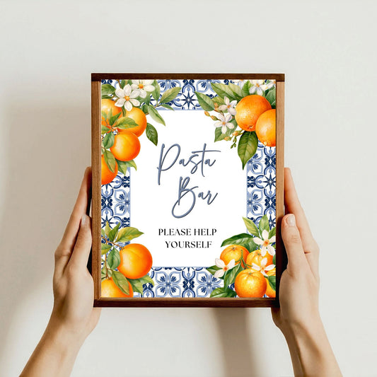 Framed sign with 'Pasta Bar' text and decorative orange design held by hands against a light background