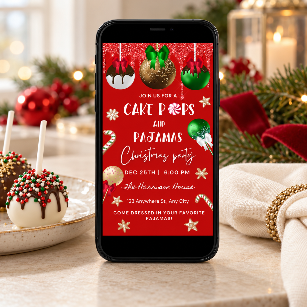 Christmas Cake Pops & Pajamas Party Invitation on a phone with festive decorations and cake pops in the background.