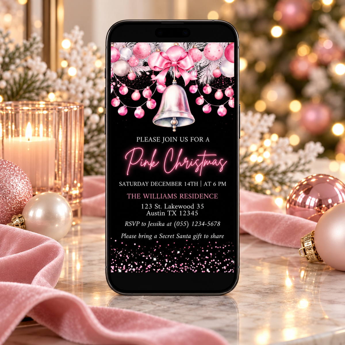Digital Chic Pink Christmas Party Invitation on a phone among holiday decorations, featuring a festive design for a Christmas celebration.
